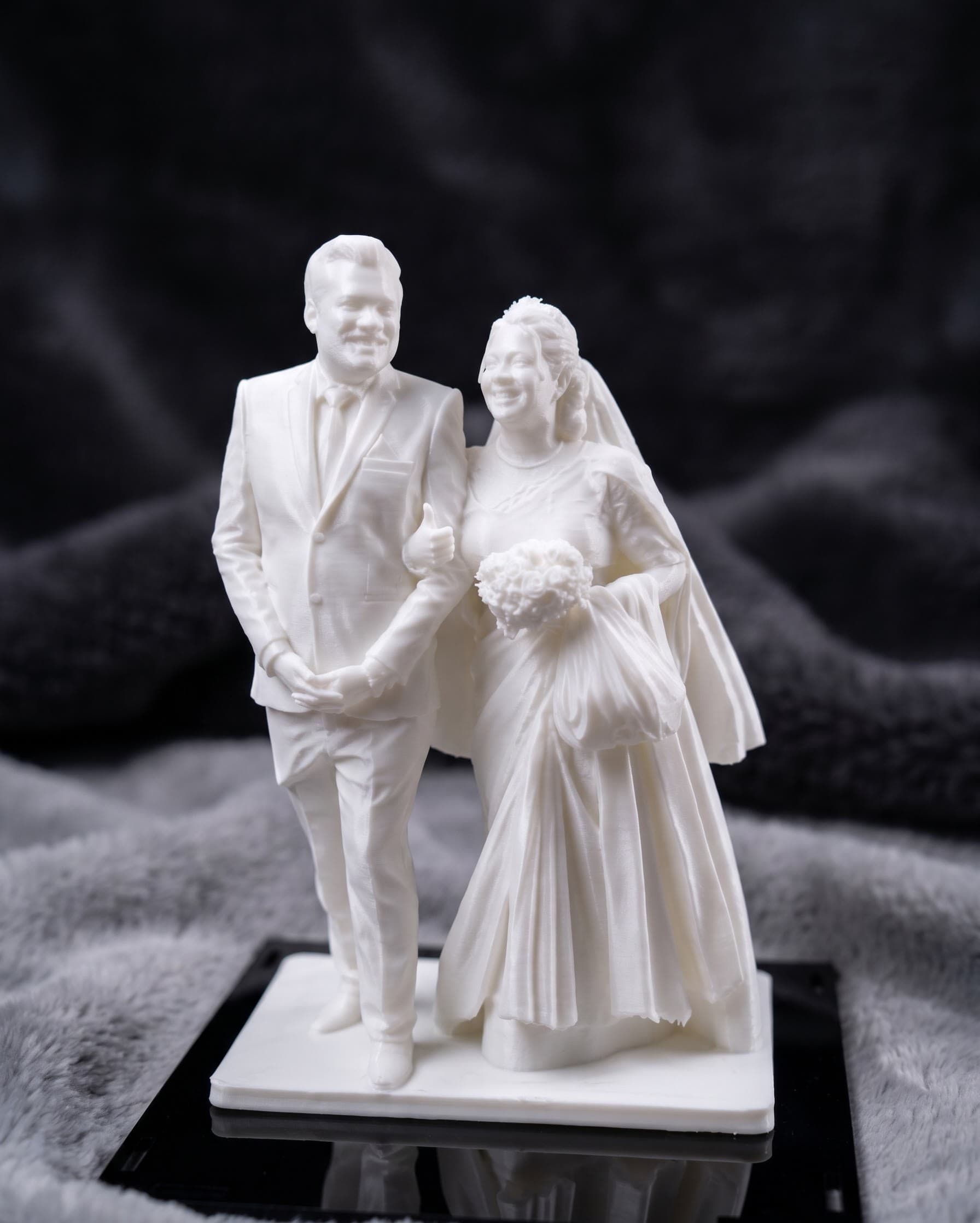 A bride and groom figure, arm in arm, finished in soft matte white with fine dress and veil detail.